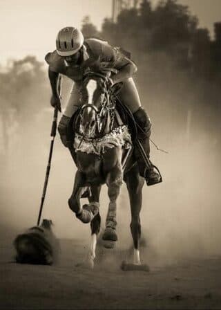 فارس بولو ينطلق بجواده في الملعب | A polo player riding at speed across the field